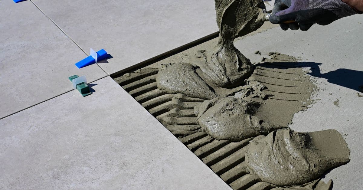 Applying grout between floor tiles during the tile grouting process